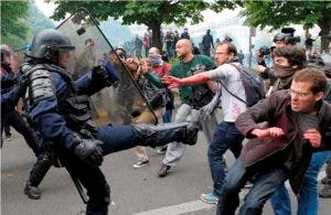 Manifestantes y policías enfrentados durante las protestas contra la reforma laboral.