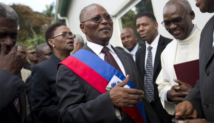 Haiti's provisional President Jocelerme Privert greets a friend during his installation ceremony, in Port-au-Prince, Haiti, Sunday, Feb. 14, 2016. Haitian lawmakers have chosen Privert, the country's Senate chief to lead a caretaker government that will fill the void left by the recent departure of ex-President Michel Martelly. (AP Photo/Dieu Nalio Chery)