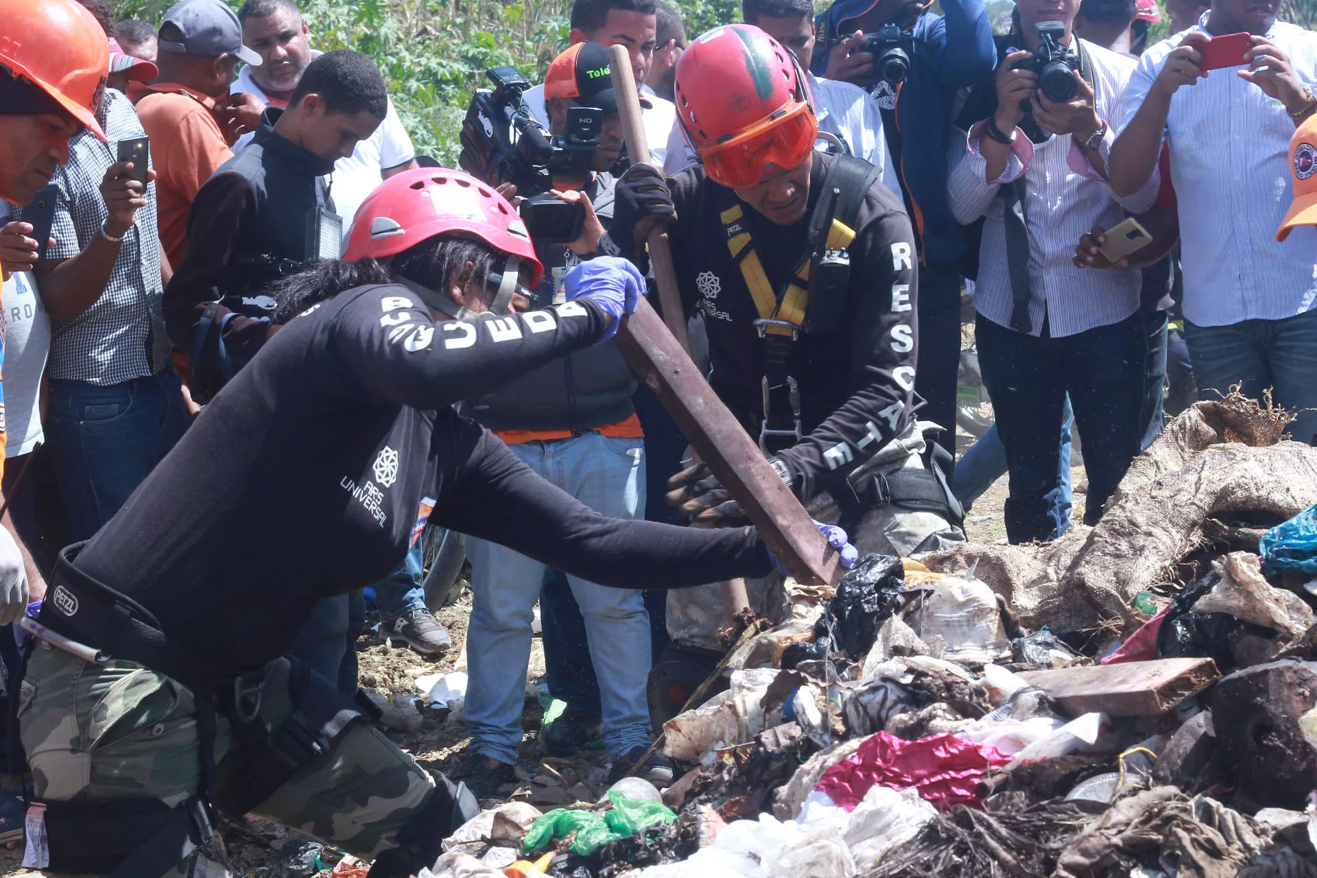 Brigadistas buscan entre los desperdicios el cadáver de Emely Peguero, luego de que el novio confesara que la mató y que la había lanzado en ese lugar. Foto: Elieser Tapia/El Día.