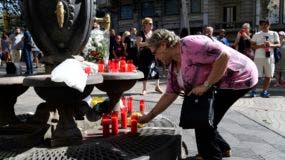 Una mujer deposita una vela en homenaje a las víctimas del atentado terrorista en La Rambla.