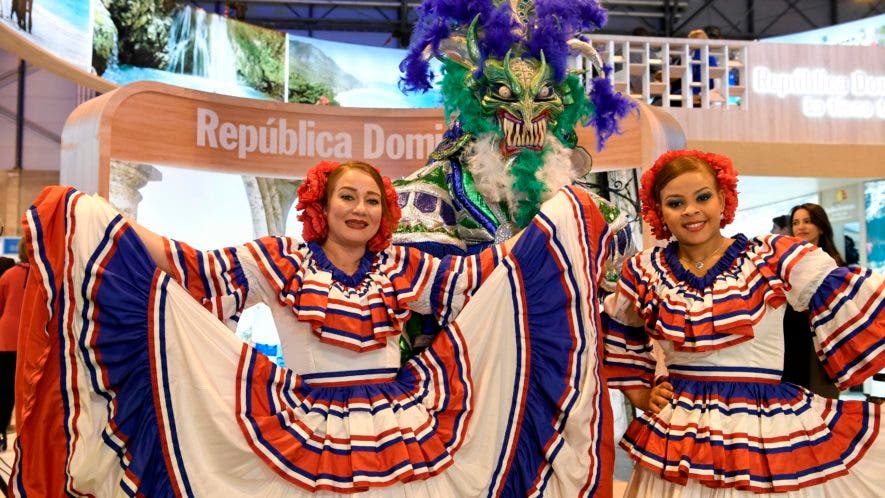 Mujeres que visten atuendos tradicionales posan en el stand de República Dominicana durante la Feria Internacional de Turismo (FITUR) en Madrid/ AFP