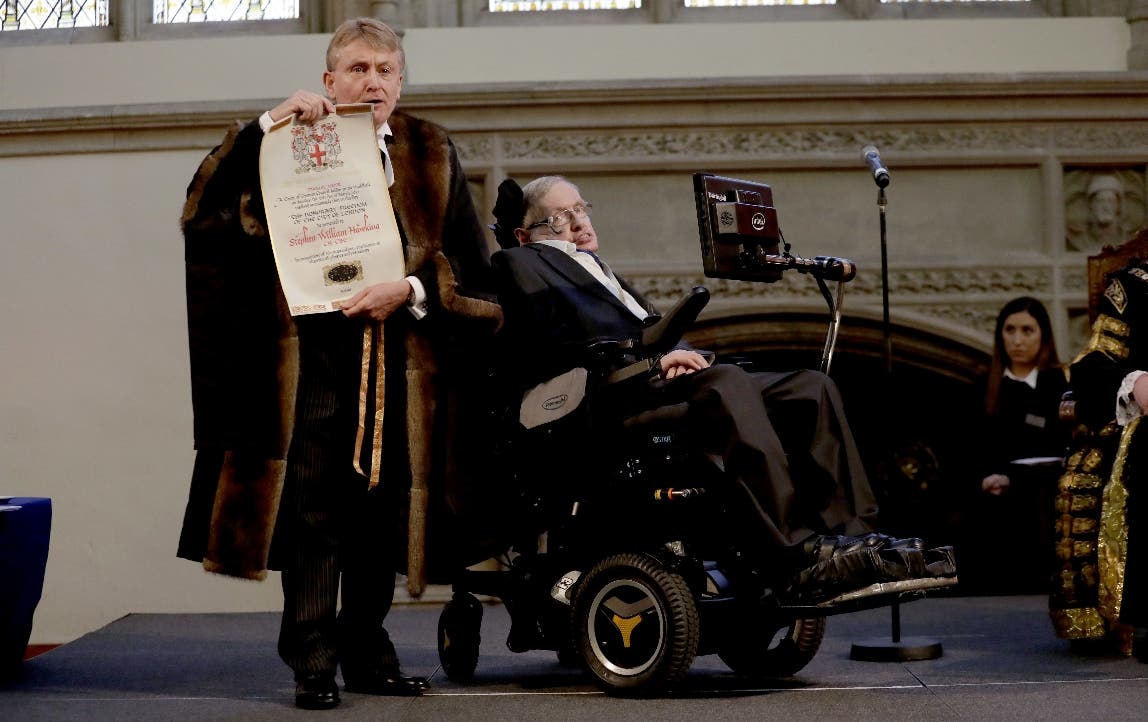 En esta foto del 6 de marzo de 2017, Stephen Hawking recibe un reconocimiento de la Ciudad de Londres de manos del director de finanzas Peter Kane. Hawking recibió innumerables reconocimientos en su vida, pero no el premio Nobel de física porque sus ideas no han sido demostradas.  (AP Foto/Matt Dunham, File)