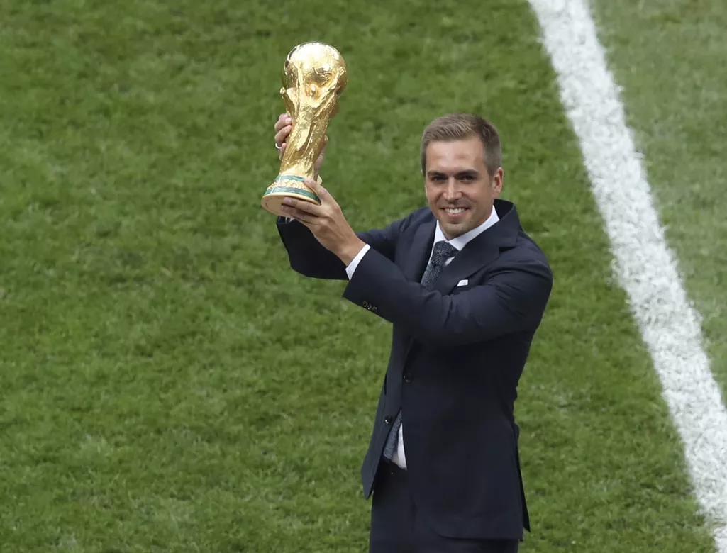 9. El excapitán de la selección alemana Philipp Lahm muestra la Copa del Mundo que conquistó cuatro años atrás, antes de la final entre Francia y Croacia, el domingo 15 de julio de 2018, en el estadio Luzhniki de Moscú (AP Foto/Thanassis Stavrakis)