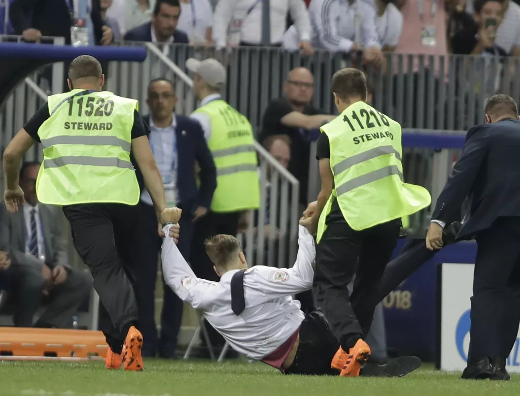 13. Personal de seguridad retira de la cancha a un sujeto que la invadió durante la final entre Francia y Croacia, el domingo 15 de julio de 2018 en el esstadio Luzhniki de Moscú (Foto/Natacha Pisarenko)