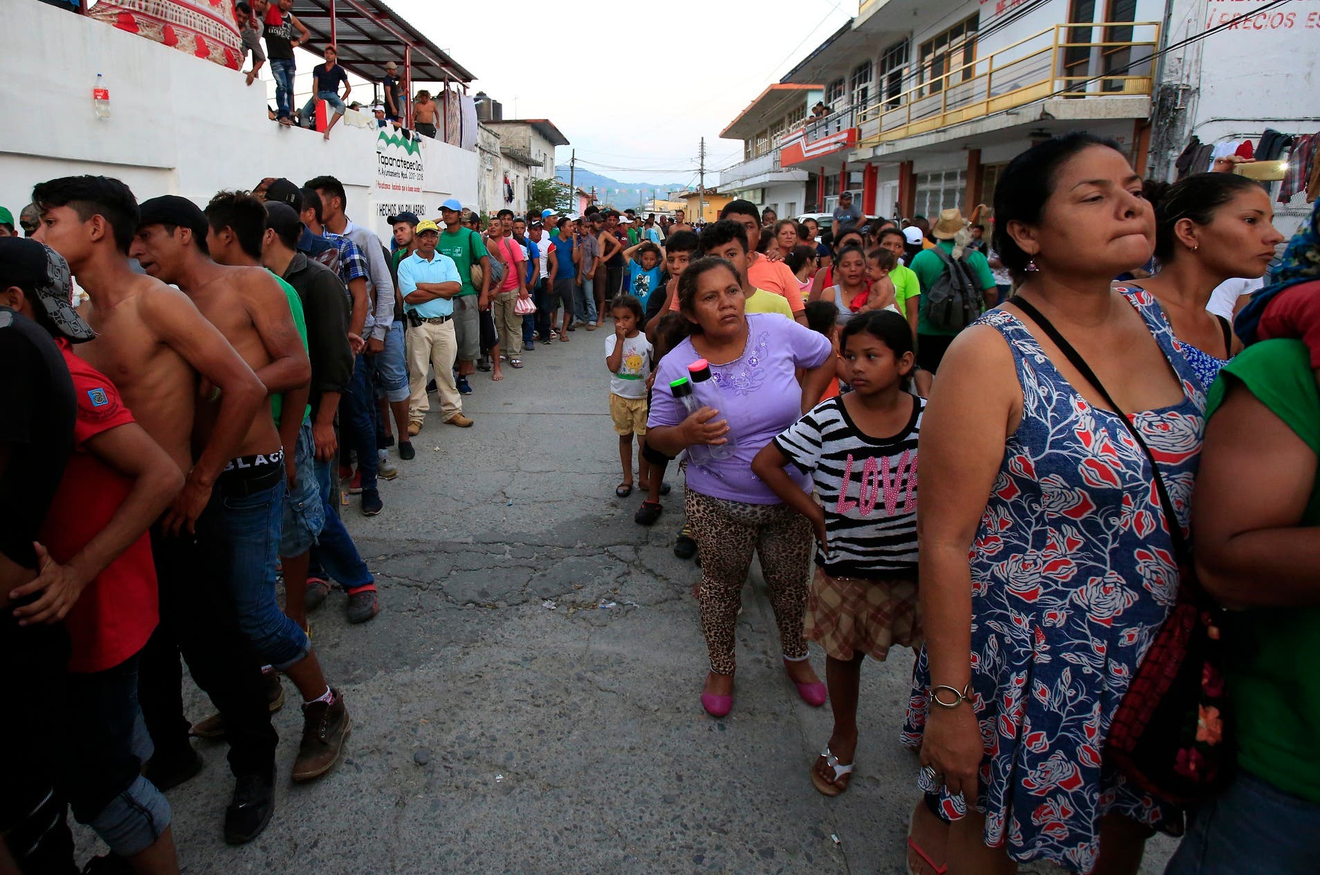Los migrantes esperan en fila para recibir alimentos donados, mientras una caravana de centroamericanos que intentan llegar a la frontera con Estados Unidos se detiene en un dÃ­a de descanso en Tapanatepec, MÃ©xico, el domingo 28 de octubre de 2018. (AP Foto / Rebecca Blackwell)