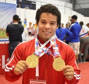 El pesista Luis GarcÃ­a muestra las medallas obtenidas.