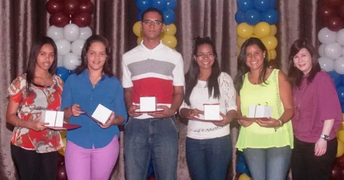 Neyda Iglesias  junto a los jóvenes reconocidos por la entidad.