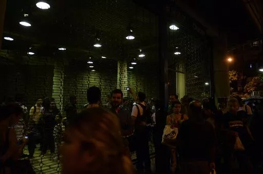 Personas esperan fuera de una estación de metro con luces de emergencia encendidas en medio de un apagón general que afectó a la capital de Venezuela y otras ciudades, el 2 de diciembre de 2013, en Caracas. Foto: AFP.