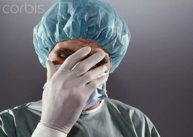 Desperate surgeon with hand before his face