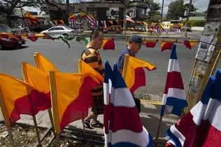 Dos hombres caminan frente a banderas de Costa Rica y de partidos políticos en San José, el sábado 5 de abril de 2014. Costa Rica vota el domingo en segunda vuelta de las elecciones presidenciales, para elegir entre el opositor Luis Guillermo Solís y el candidato oficialista Johnny Araya. MOISÉS CASTILLO / FOTO AP.