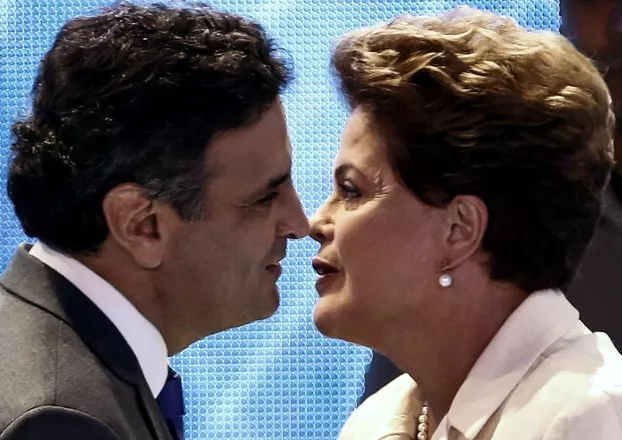 (FILE) Presidential candidate for the Brazilian Workers' Party and current President Dilma Rousseff (R) greets Brazilian Social Democracy Party candidate Aecio Neves before a television debate in Sao Paulo, Brazil on August 26, 2014. Rousseff and Neves will face on October 26 run-off. AFP PHOTO / Miguel SCHINCARIOL