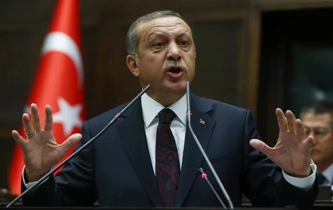 (FILES) -- A file photo taken on April 8, 2014 shows Turkey's Prime Minister Recep Tayyip Erdogan speaking to members of Parliament from his ruling Justice and Development (AKP) Party during a meeting at the Turkish parliament in Ankara. Erdogan on December 15, 2014 lashed out at the European Union for criticising the mass arrests targeting opposition media outlets, telling Brussels to "mind its own business." "The European Union cannot interfere in steps taken... within the rule of law against elements that threaten our national security," Erdogan said in televised remarks, his first comments after Sunday's raids. "They should mind their own business." AFP PHOTO / ADEM ALTAN