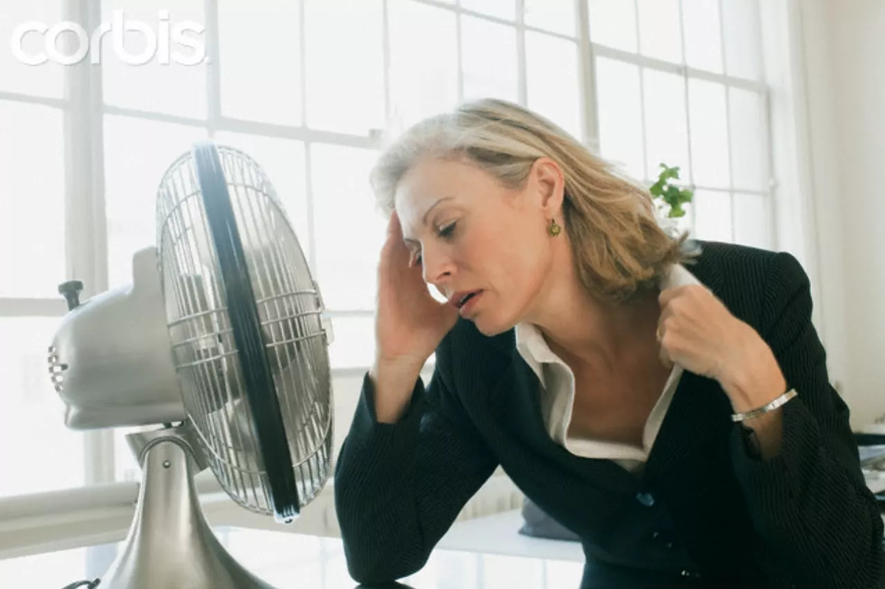 Hot businesswoman sitting in front of fan