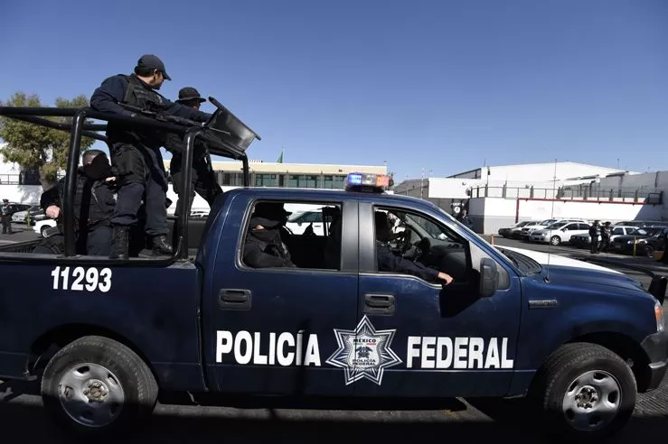 Mexican Federal Police personnel on a pickup stand guard outside the General Prosecutor’s office in Mexico City on February 27, 2015. Mexican federal police captured Knights Templar drug cartel leader Servando Gomez, aka "La Tuta" on Friday, taking down one of the country’s most wanted fugitives whose gang tormented the western state of Michoacan.  AFP PHOTO/ALFREDO ESTRELLA