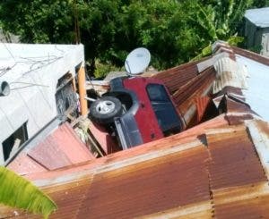 Profesora pisa el acelerador y su yipeta cae encima de una casa