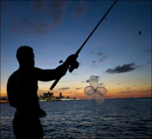 El mecánico Junio Torres López prepara la caña para lanzar su anzuelo con condones, una práctica conocida como “pesca con globo”, en el Malecón de La Habana, Cuba, el 13 de noviembre de 2016. (AP Foto/Ramon Espinosa)  