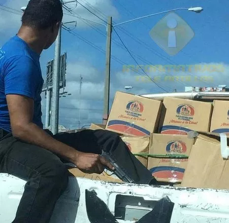 Tras ola de asalto, hombre armado custodia vehículo con cajas navideñas