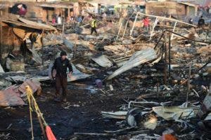 Los bomberos trabajan en medio de los escombros dejados por una explosión enorme que ocurrió en un mercado de fuegos artificiales en la Ciudad de México