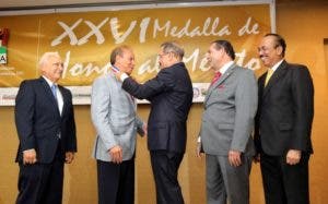 El presidente Medina entrega a Rondón la Medalla al Mérito en Ganadería, otorgada por la Asociación Dominicana de Hacendados y Agricultores (ADHA), por sus aportes al desarrollo de la producción agropecuaria nacional, en octubre de 2013. 