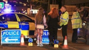 Una joven herida sale escoltada por varios agentes de policía minutos después del ataque al Manchester Arena. 