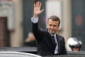 French President Emmanuel Macron waves as he parades in a Citroen DS car on the Champs Elysees avenue after his formal inauguration ceremony as French President on May 14, 2017 in Paris. / AFP / CHARLY TRIBALLEAU