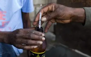 En esta imagen, trabajadores miden el nivel de alcohol del clairin, una bebida elaborada a partir de caña de azúcar, antes de rebajarlo hasta el 45 o el 50%, en la destilería Ti Jean, en Leogane, Haití. AP
