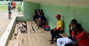 Los atletas observan las malas  condiciones de  uno de los dugouts del estadio Hermanos Suárez,  en San Juan de la Maguana.