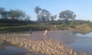 Residentes en sectores de Montellano cruzan a pie río Camú tras desplome de puente