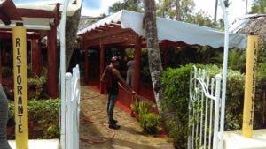 Un empleado de un restaurante limpia la entrada al negocio que ya está listo para recibir a sus clientes. Foto: Elieser Tapia/El Día.