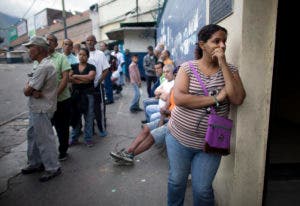  Los votantes esperan en fila para emitir sus votos fuera de una mesa de votación en Caracas. AP