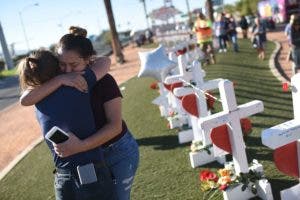 Melissa Gerber (L) y Sandra Serralde (R) se sienten cómodas al lado de 58 cruces blancas para las víctimas del tiroteo de la noche del domingo en el extremo sur de Las Vegas Strip, el 6 de octubre de 2017 en Las Vegas, Nevada.