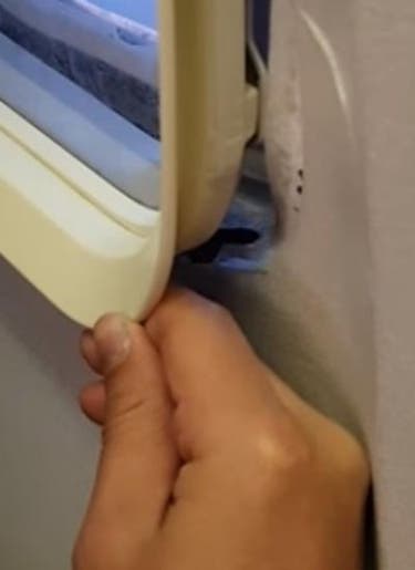 Pasajero despega ventanilla de un avión en vuelo