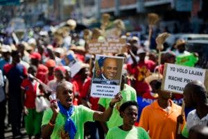  Un manifestante sostiene una pancarta que muestra una imagen del ex presidente de Haití Michel Martely con un mensaje que dice en créole: "Aquí está la persona que robó el dinero de PetroCaribe". AP