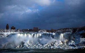 El agua corre por la catarata Estadounidense entre el hielo, en el lado canadiense de las Cataratas del Niágara, en Ontario, el 2 de enero de 2018.  (Aaron Lynett/The Canadian Press via AP)