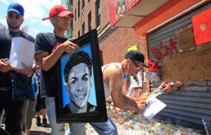 En esta foto de archivo del 26 de junio de 2018, José Bencosme sostiene una pintura de su primo Lesandro Guzmán-Feliz de 15 años, un obsequio del artista famoso Samil Alva, mientras visita un memorial comunitario para Guzmán-Feliz, quien era asesinado la semana anterior en un ataque de machete, en el barrio del Bronx de Nueva York. AP