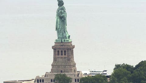 Mujer escala la base de la Estatua de la Libertad en protesta por la política inmigratoria de EEUU