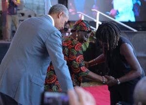 Obama y su heramana Auma Obama, ayudan a sentarse a a su abuela Sarah Obama  durante un evento este lunes en Kogelo, Kisumu, Kenya.