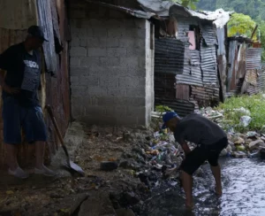 Moradores de la Ciénega sacan basura arrastrada por el río.