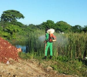 Un empleado de Obras Públicas fumiga en un terreno contiguo a la escuela y donde también se acumula agua. En este lugar fue detectado el mosquito que transmite la malaria.