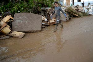 Un hombre pasa junto a los muebles dañados después de las inundaciones, en Sant Llorenc, a 60 kilómetros (40 millas) al este de la capital de Mallorca, Palma, España. AP