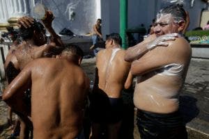 Centroamericanos toman un baño durante una pausa en su marcha hacia Estados Unidos.