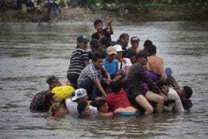 Migrantes cruzando un río entre Guatemala y México. (AP Photo/Moises Castillo)