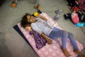 Una niña descansa junto a su muñeca en un refugio instalado para un grupo que se separó de la caravana de migrantes centroamericanos que espera llegar a la frontera de México con Estados Unidos, en Córdoba, estado de Veracruz, México, 4 de noviembre de 2018.  (AP Foto/Rodrigo Abd)