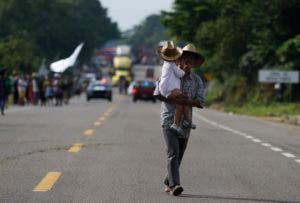 Un padre con su hijo en la caravana de migrantes que busca llegar a Estados Unidos. (AP Photo/Marco Ugarte)