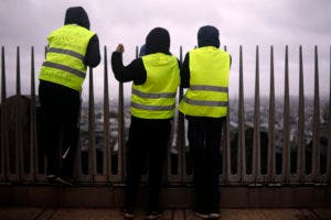 Los manifestantes observan desde la cima del Arco de Triunfo en la avenida Champs-Elysees durante una demostración. AP