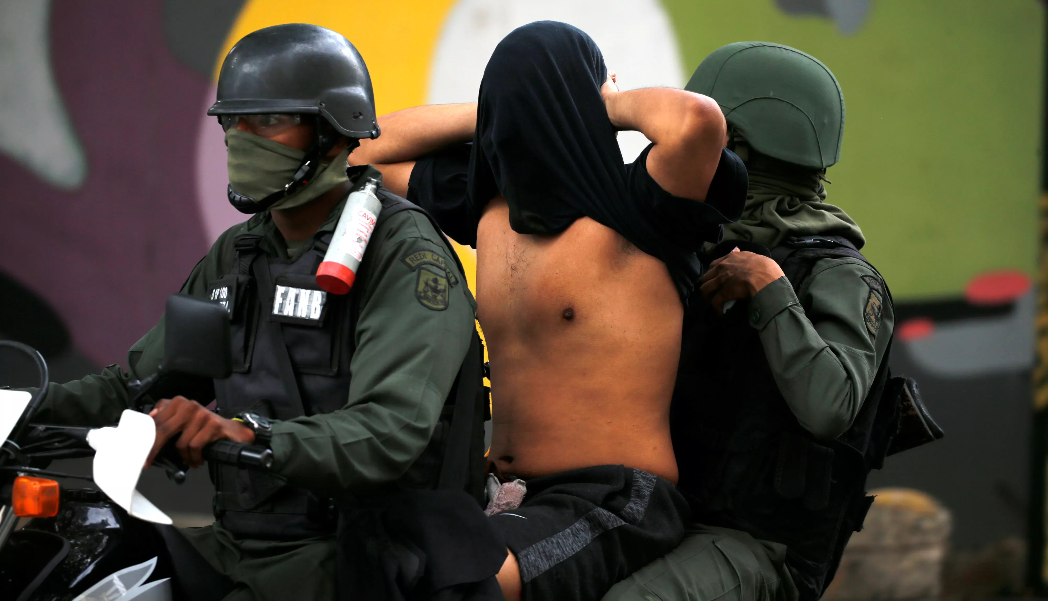 9. Miembros de la Guardia Bolivariana detienen a un manifestante después de un evento que pedía la renuncia del presidente Nicolás Maduro en Caracas.