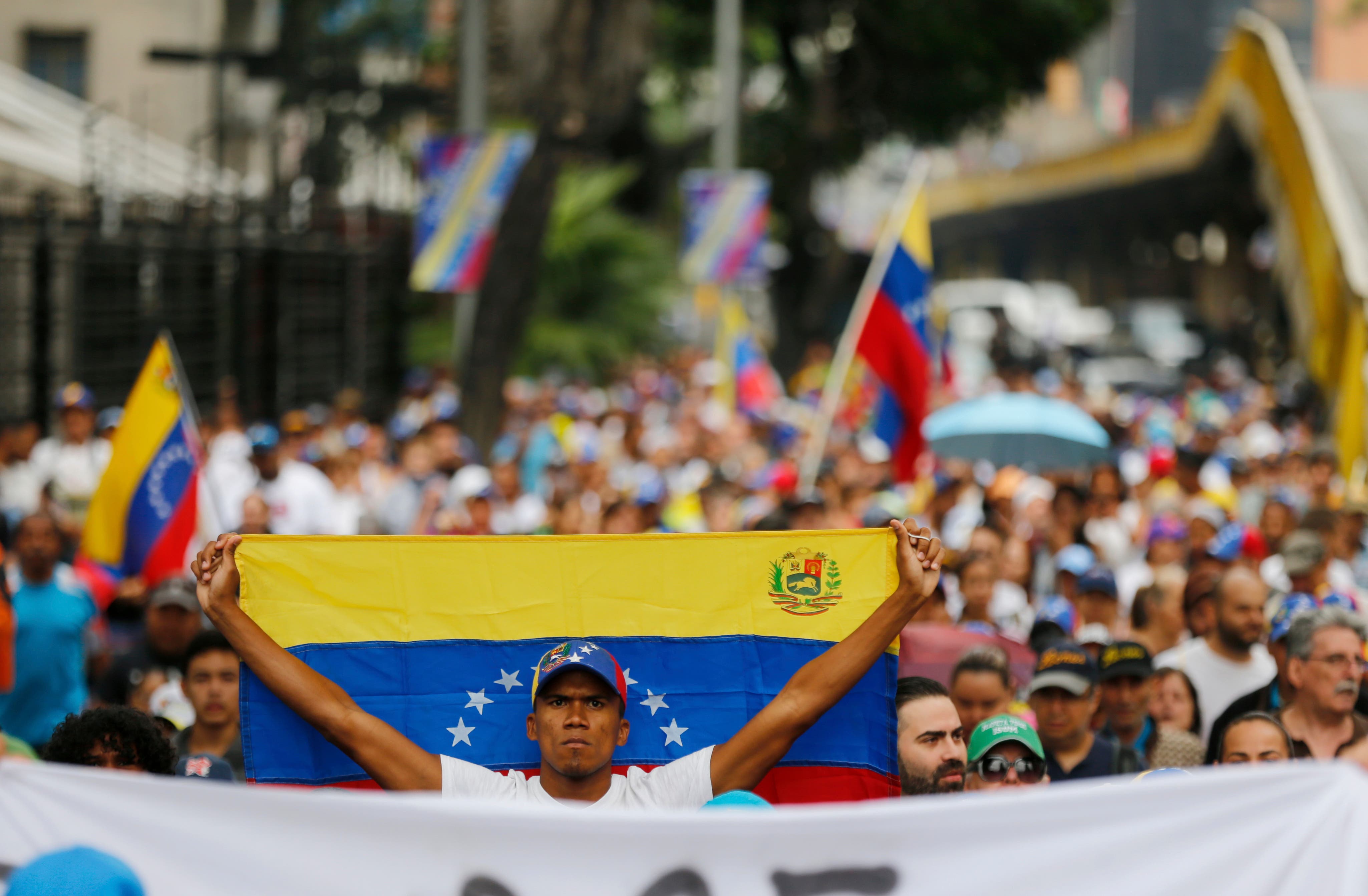 Un miembro de la oposición sostiene una bandera nacional venezolana durante una marcha de protesta contra el presidente Nicolás Maduro en Caracas, Venezuela.