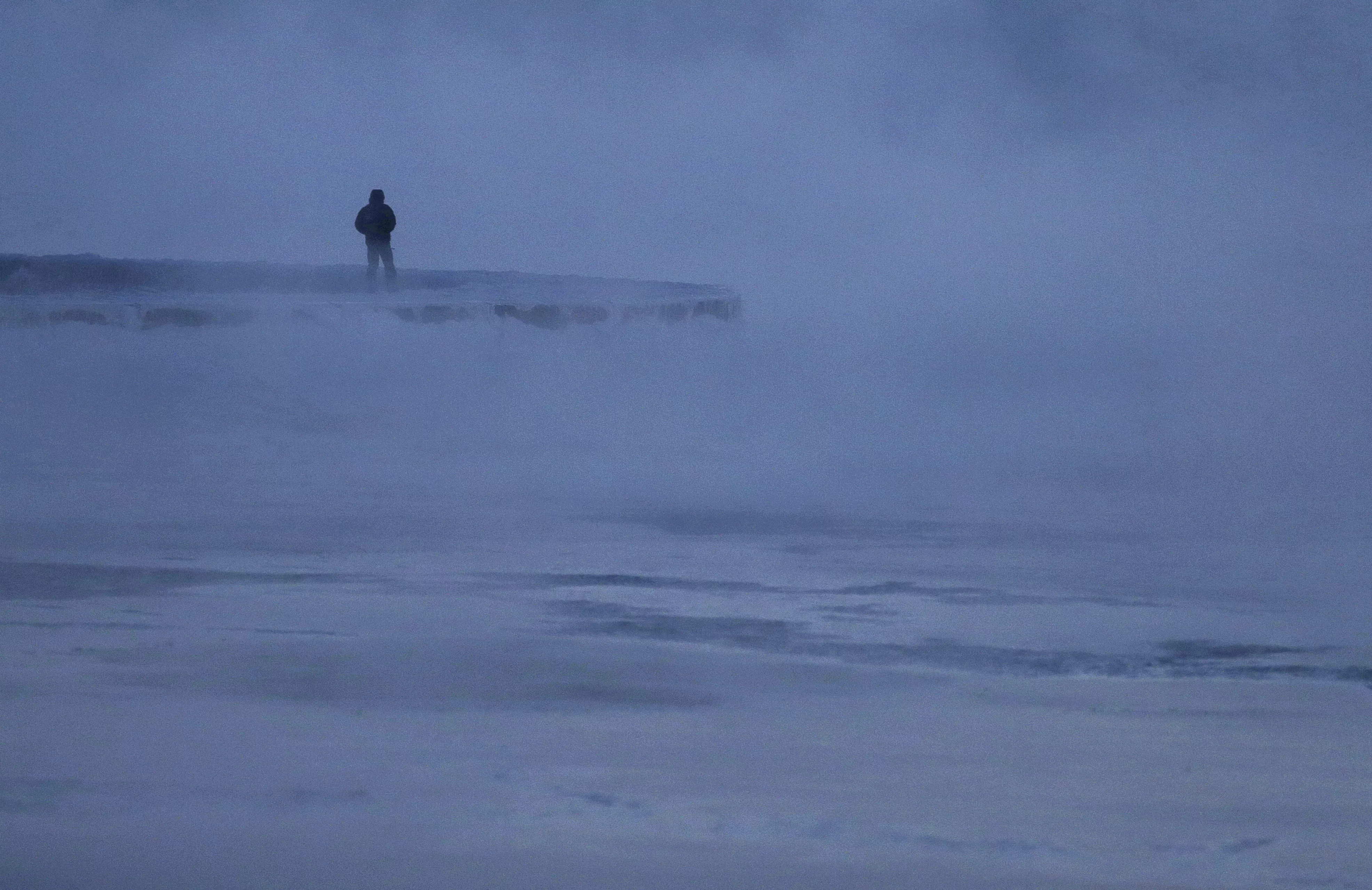 11. Un hombre camina a lo largo de la orilla del lago Michigan. AP