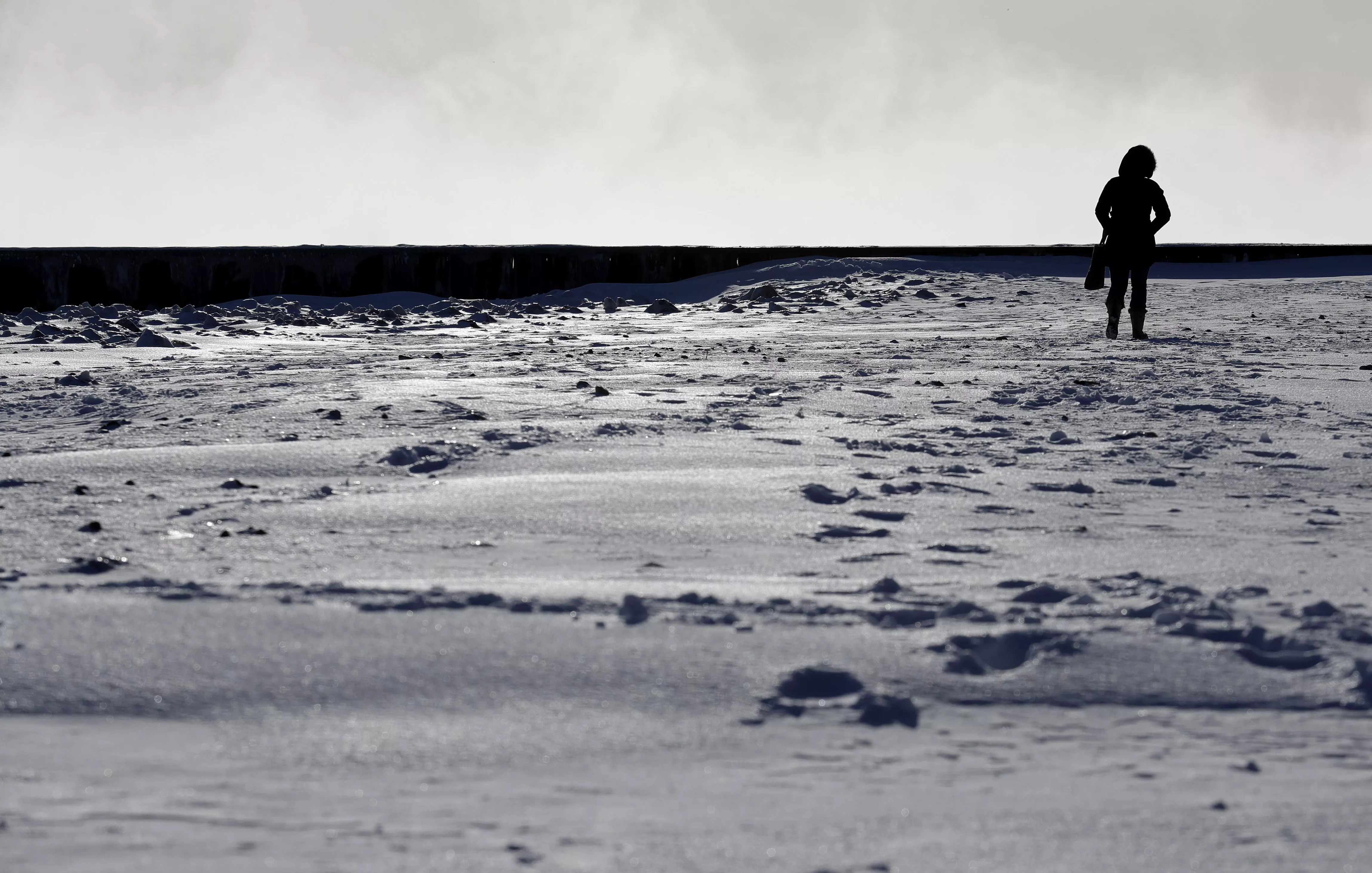 6. Una mujer camina a lo largo de la orilla del lago Michigan en el Lighthouse Park en Evanston, Illinois. AP