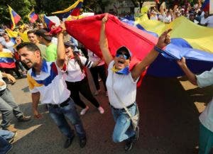 En esta imagen del 12 de febrero de 2019, manifestantes gritan consignas en contra del presidente de Venezuela Nicolás Maduro en Ureña, Venezuela, una localidad ubicada en la frontera con Colombia. Casi tres semanas después de que el gobierno del presidente Donald Trump respaldó un intento por obligar a la salida de Maduro, el asediado mandatario se aferra al poder y desafía los pronósticos de una salida inminente. (AP Foto/Fernando Llano)